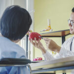 Man doctor neurologist is showing a elder female patient