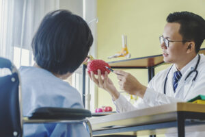 Man doctor neurologist is showing a elder female patient