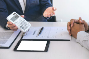 Businessman being analysis and making the decision a car insurance policy, Agent man is using calculator to presentation detail and waiting for his reply to finish