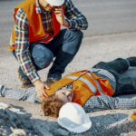 Worried man calling ambulance for his unconscious coworker