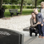 Young family visiting grave of family