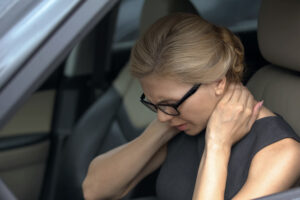 Exhausted woman feeling neck pain, sitting in automobile, spinal problem, health