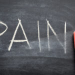 erasing pain, hand written word on blackboard being erased concept erasing pain, hand written word on blackboard being erased concept